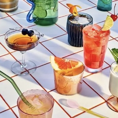 A colorful selection of cocktails arranged on a tiled table